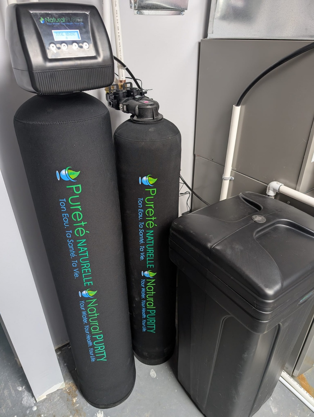 Twin tank conditioner and carbon filter installed side by side in a utility room